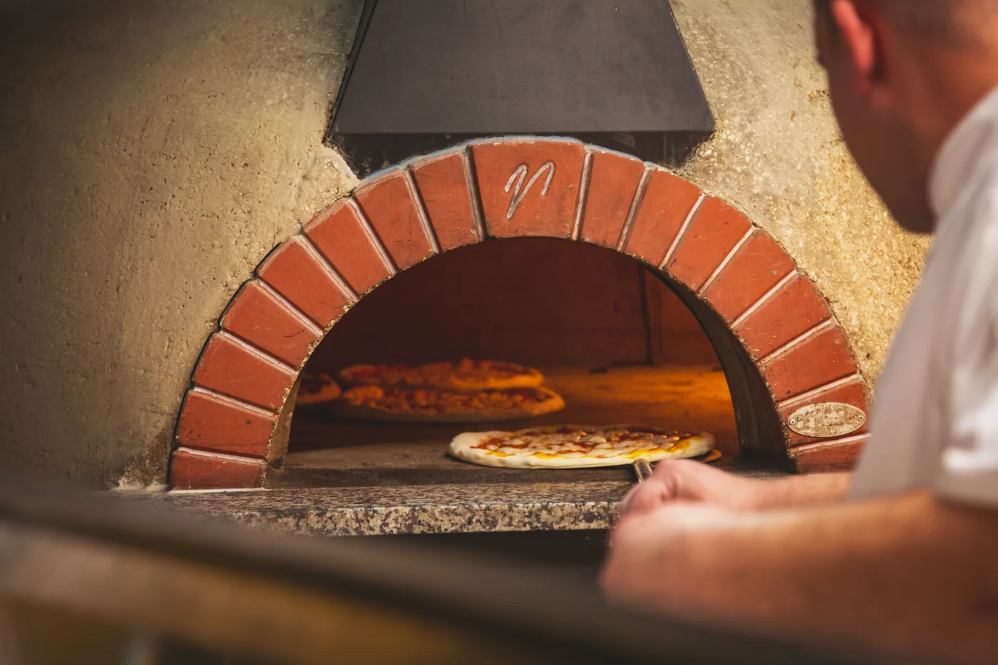 The copper pizza oven with the pizzaiolo at work